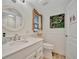 Bright bathroom featuring vanity with drawers, decoratively framed window, and wood-look flooring at 7817 Alhambra Dr, Bradenton, FL 34209
