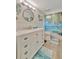 Well-lit bathroom featuring wood-look floors, vanity with drawers, and colorful shower curtain at 7817 Alhambra Dr, Bradenton, FL 34209