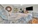 Well-lit bedroom with a wooden-framed mirror, large TV and view to the outdoors at 7817 Alhambra Dr, Bradenton, FL 34209