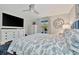 Comfortable bedroom with blue accents, hardwood floors, and a large TV at 7817 Alhambra Dr, Bradenton, FL 34209