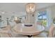 Elegant dining room with a round table, chandelier, and large windows overlooking the outdoors at 7817 Alhambra Dr, Bradenton, FL 34209