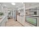 Modern kitchen with stainless steel appliances and white cabinets, seamlessly connecting to the dining area at 7817 Alhambra Dr, Bradenton, FL 34209