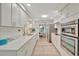 Spacious kitchen featuring white cabinetry, stainless steel appliances, and views of the dining area at 7817 Alhambra Dr, Bradenton, FL 34209