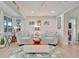 Bright living room with white wainscoting, comfortable seating, and a tropical rug at 7817 Alhambra Dr, Bradenton, FL 34209