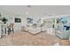 Bright, modern living room with white furniture and a comfortable sectional sofa and lots of natural light at 7817 Alhambra Dr, Bradenton, FL 34209