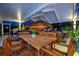 Outdoor dining area with seating for six under covered patio next to built-in tiki bar at 7817 Alhambra Dr, Bradenton, FL 34209