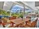 Covered outdoor seating area features a dining table and comfortable lounge furniture overlooking the pool and well-manicured yard at 7817 Alhambra Dr, Bradenton, FL 34209
