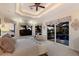 This main bedroom features a tray ceiling, a ceiling fan, and access to a pool with waterfront views at 801 3Rd E St, Palmetto, FL 34221