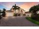 Stately home with lush landscaping, paver driveway, and porte cochere garages at sunset at 801 3Rd E St, Palmetto, FL 34221