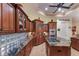 Kitchen featuring granite counters, custom cabinetry, and island with cooktop at 801 3Rd E St, Palmetto, FL 34221