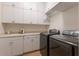 Bright laundry room with modern appliances, storage cabinets, folding counter space, and a utility sink at 801 3Rd E St, Palmetto, FL 34221