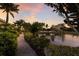 A peaceful walkway along a pond, lined with green plants, leading to a high-rise building at 801 3Rd E St, Palmetto, FL 34221