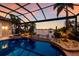 Inviting pool and spa area with a screened enclosure, featuring lush landscaping and waterfront access at 801 3Rd E St, Palmetto, FL 34221