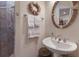 Bathroom with pedestal sink, decorative mirror, and convenient walk-in shower at 801 3Rd E St, Palmetto, FL 34221