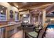 Outdoor kitchen area featuring a built-in grill, bar seating, and direct access to the pool and patio at 801 3Rd E St, Palmetto, FL 34221