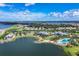 Sprawling community aerial featuring a large lake, a pool and luxuriously landscaped homes at 8069 Tidal Pointe Way, Sarasota, FL 34240
