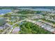 An aerial view showcasing the community's pools, tennis courts, and winding roads amidst lush greenery at 8069 Tidal Pointe Way, Sarasota, FL 34240