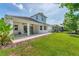 Beautiful backyard with a covered patio, green lawn, and professionally landscaped garden at 8069 Tidal Pointe Way, Sarasota, FL 34240
