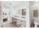 Luxurious bathroom with double sinks, sleek vanity and illuminated mirror, plus private commode at 8069 Tidal Pointe Way, Sarasota, FL 34240