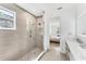 Sleek bathroom design with glass-enclosed shower and views through to the main bedroom at 8069 Tidal Pointe Way, Sarasota, FL 34240