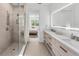 Modern bathroom featuring double vanity, frameless glass shower, and access to main bedroom at 8069 Tidal Pointe Way, Sarasota, FL 34240