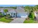 The front of a beautifully landscaped home, featuring a pristine lawn and an elegant entrance at 8069 Tidal Pointe Way, Sarasota, FL 34240