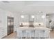 Bright white kitchen features a large island with seating, stainless steel appliances, and modern pendant lighting at 8069 Tidal Pointe Way, Sarasota, FL 34240