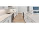 Bright kitchen with white cabinets, hardwood floors, stainless steel appliances, and an island with a sink at 8069 Tidal Pointe Way, Sarasota, FL 34240