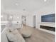 Open-concept living room features a modern fireplace and seamless flow into the bright, all-white kitchen at 8069 Tidal Pointe Way, Sarasota, FL 34240