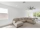 Bright living room featuring a large sectional sofa, ceiling fan, and sunlit windows at 8069 Tidal Pointe Way, Sarasota, FL 34240