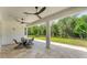Covered patio with ceiling fans, dining table, and chairs overlooks a well-maintained backyard at 8069 Tidal Pointe Way, Sarasota, FL 34240