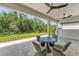 Spacious covered patio with outdoor dining furniture, ceiling fans, and a serene view of the backyard at 8069 Tidal Pointe Way, Sarasota, FL 34240