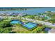 Aerial showcasing well-maintained tennis and pickleball courts with views of the surrounding homes and neighborhood at 8069 Tidal Pointe Way, Sarasota, FL 34240