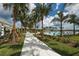 A serene pool area with palm trees, a covered seating area, and a view of the lake at 8069 Tidal Pointe Way, Sarasota, FL 34240