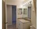 Bathroom featuring a granite countertop vanity, a lighted mirror and neutral colored wall paint at 8755 Olde Hickory Ave # 7107, Sarasota, FL 34238