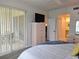 Bright bedroom featuring a television, sliding glass doors and access to an ensuite bathroom at 8755 Olde Hickory Ave # 7107, Sarasota, FL 34238