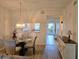 Bright dining area featuring modern lighting, a view to the entry and laminate floors at 8755 Olde Hickory Ave # 7107, Sarasota, FL 34238