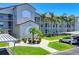 Exterior view of building featuring well-maintained landscaping and covered parking on a bright, sunny day at 8755 Olde Hickory Ave # 7107, Sarasota, FL 34238