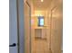 Hallway featuring neutral paint, closet doors and tile flooring that leads to the bathroom vanity at 8755 Olde Hickory Ave # 7107, Sarasota, FL 34238