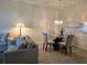 Living room area featuring sofa, glass dining table and laminate floors at 8755 Olde Hickory Ave # 7107, Sarasota, FL 34238