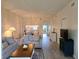 Living room showcasing a comfortable sofa, a view into the dining area, and laminate floors at 8755 Olde Hickory Ave # 7107, Sarasota, FL 34238