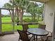 Relaxing screened-in patio features a golf course view, table, and chairs, creating an inviting outdoor space at 8755 Olde Hickory Ave # 7107, Sarasota, FL 34238