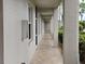View of a covered exterior walkway with tile flooring and white walls at 8755 Olde Hickory Ave # 7107, Sarasota, FL 34238