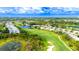Expansive aerial shot of a well-maintained golf course winding through a lovely residential neighborhood with ponds at 8979 Grey Oaks Ave, Sarasota, FL 34238