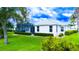 Lush green backyard featuring well-maintained lawn and manicured shrubs, offering a serene outdoor space at 8979 Grey Oaks Ave, Sarasota, FL 34238