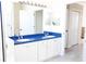 Bright bathroom featuring a double vanity, white cabinets, and a large mirror at 8979 Grey Oaks Ave, Sarasota, FL 34238