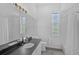Bright bathroom featuring double sinks, a large mirror with lighting, and a bathtub with shower at 8979 Grey Oaks Ave, Sarasota, FL 34238
