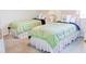 Bedroom with two twin beds, each with matching green bedding and a nightstand between at 8979 Grey Oaks Ave, Sarasota, FL 34238