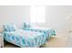 This bright bedroom features twin beds with patterned bedding and a nightstand at 8979 Grey Oaks Ave, Sarasota, FL 34238