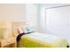 Bedroom featuring a single bed with green and blue bedding, a nightstand, and closet at 8979 Grey Oaks Ave, Sarasota, FL 34238